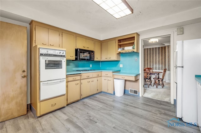 kitchen with white appliances and light hardwood / wood-style flooring