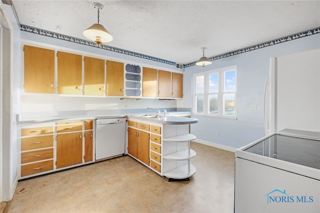 kitchen with decorative light fixtures, white appliances, kitchen peninsula, and sink