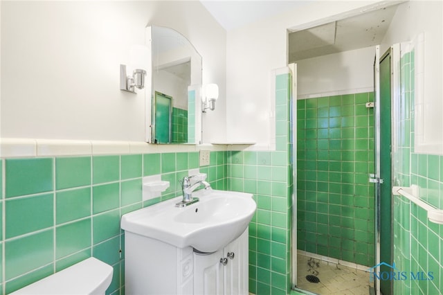 bathroom featuring vanity, toilet, tile walls, and an enclosed shower