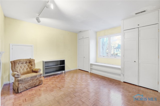 sitting room with light parquet floors and track lighting