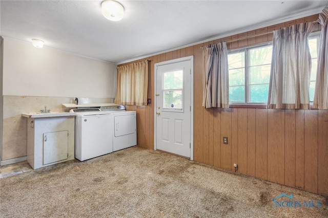 laundry area with washer and dryer, light carpet, and wooden walls