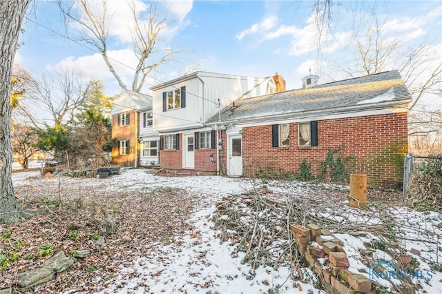 view of snow covered rear of property