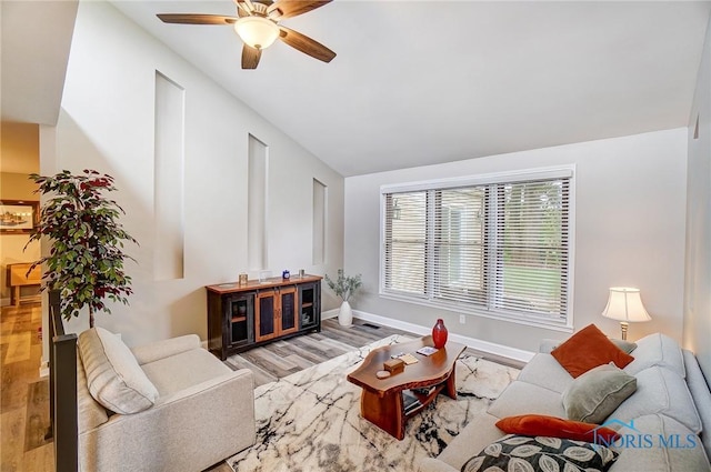 living room with ceiling fan, light hardwood / wood-style floors, and lofted ceiling