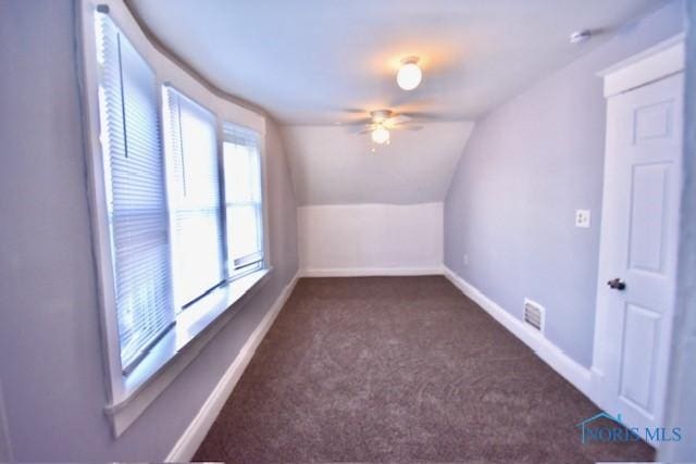 additional living space featuring vaulted ceiling, ceiling fan, and dark colored carpet