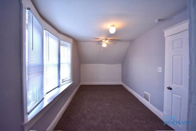 bonus room featuring ceiling fan, dark colored carpet, and lofted ceiling