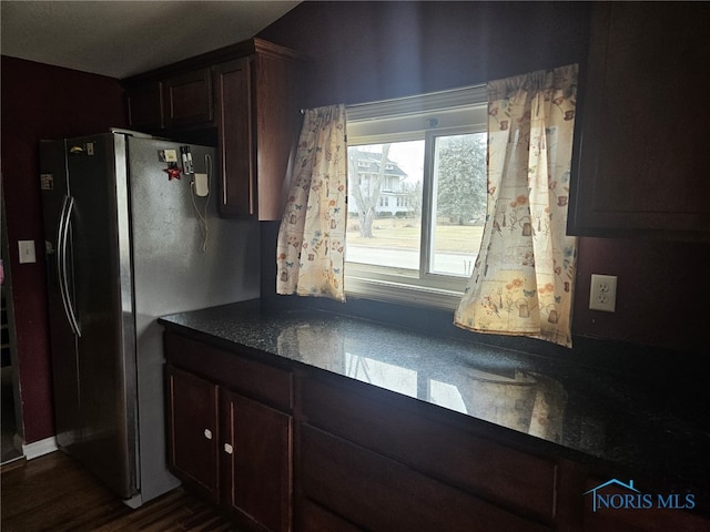 kitchen with dark stone counters and black fridge