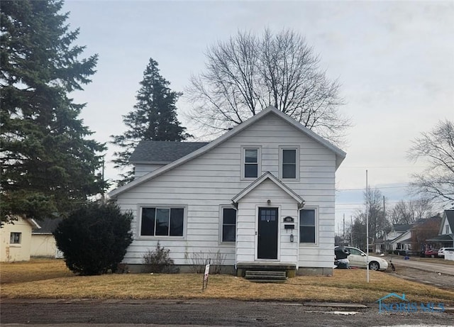 traditional-style house with entry steps and a front yard