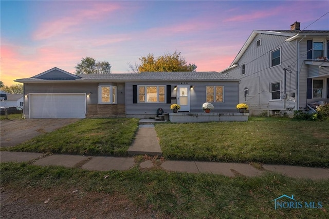 view of front of property featuring a garage and a lawn