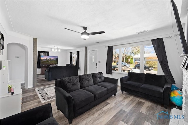 living room with hardwood / wood-style floors, ornamental molding, and a textured ceiling