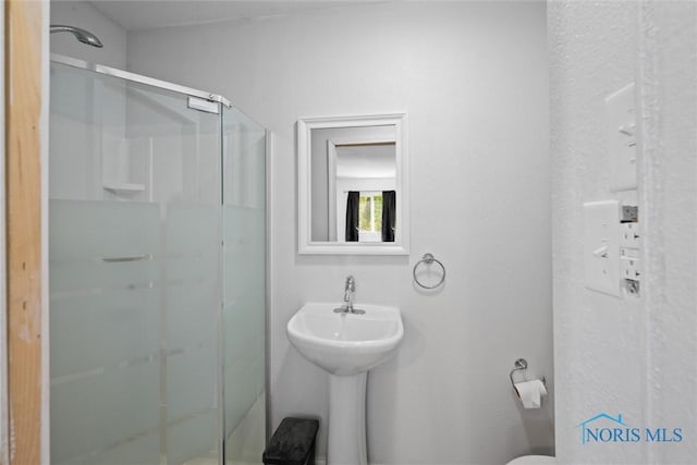 bathroom with toilet and an enclosed shower