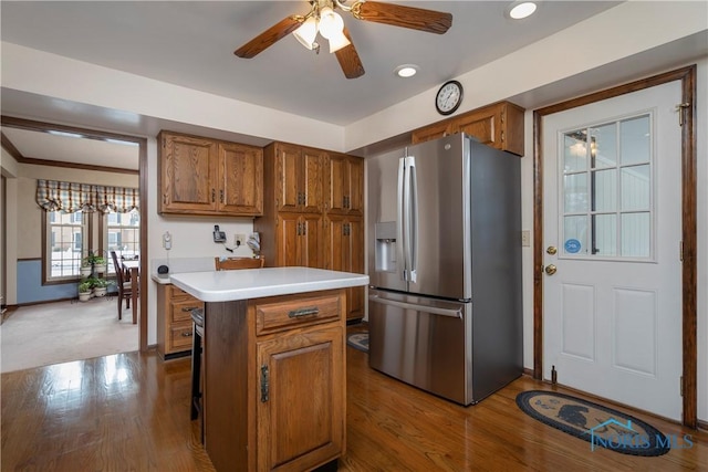 kitchen with a center island, stainless steel refrigerator with ice dispenser, ceiling fan, light hardwood / wood-style flooring, and a breakfast bar area