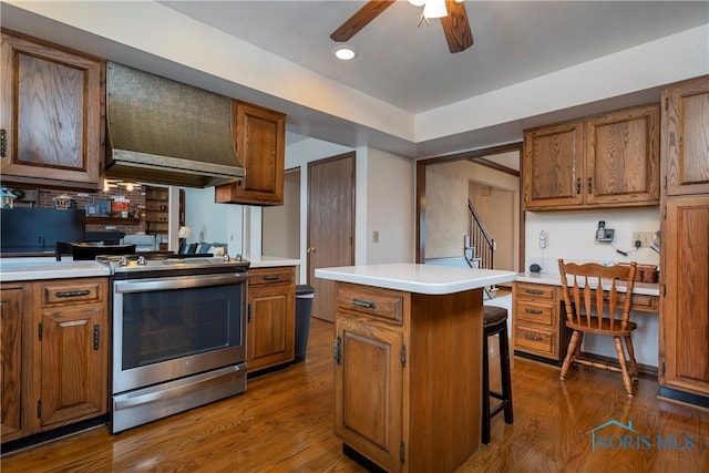 kitchen with a center island, stainless steel range oven, a kitchen bar, premium range hood, and dark hardwood / wood-style flooring