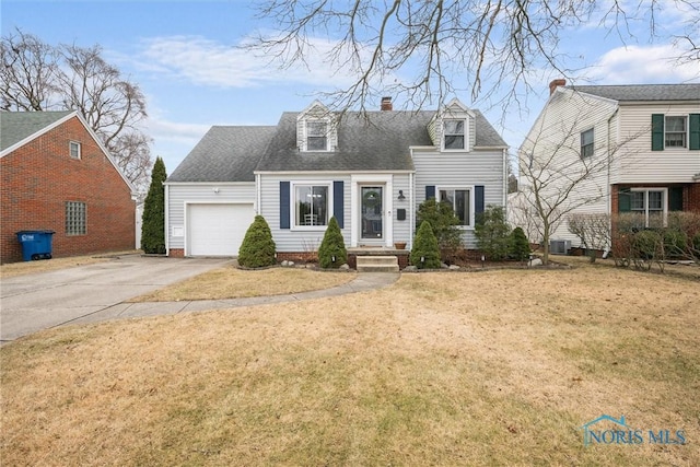 cape cod house featuring a garage and a front lawn