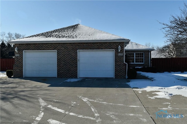 snow covered property featuring a garage