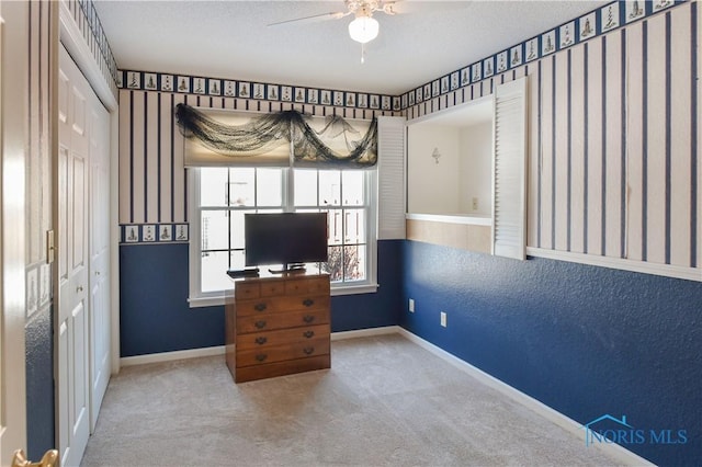 unfurnished office with carpet floors, a textured ceiling, and ceiling fan