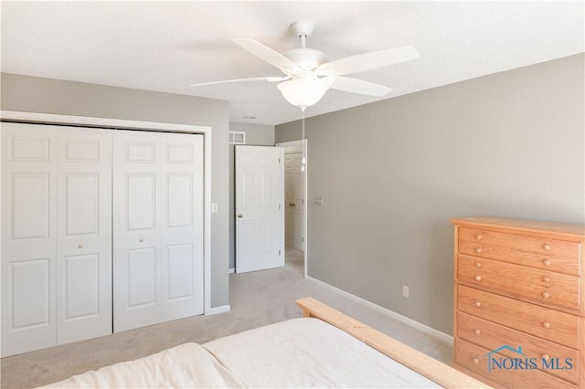 bedroom featuring light carpet, a closet, and ceiling fan