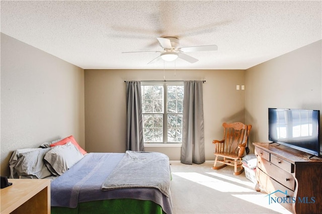 bedroom featuring carpet, a textured ceiling, and ceiling fan