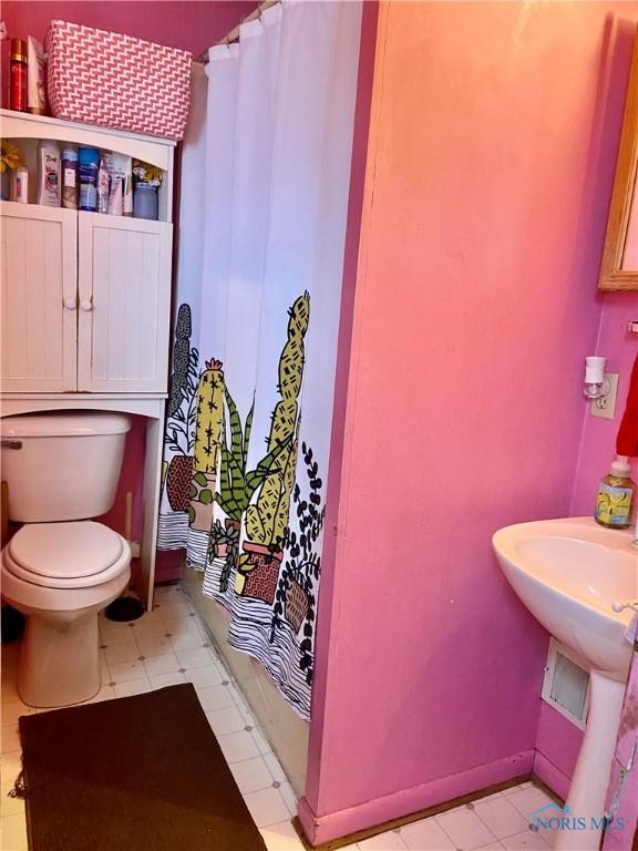 bathroom featuring toilet and walk in shower