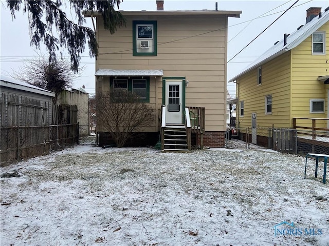 view of snow covered back of property