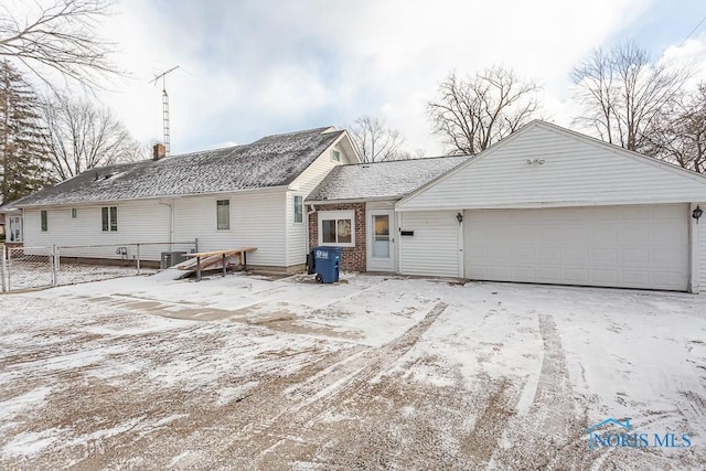 back of house with central AC unit and a garage