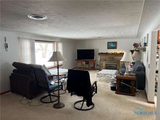 carpeted living room featuring a fireplace and a textured ceiling