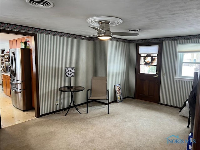 entrance foyer featuring ceiling fan and light carpet