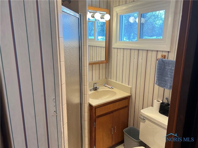 bathroom featuring vanity, walk in shower, and toilet