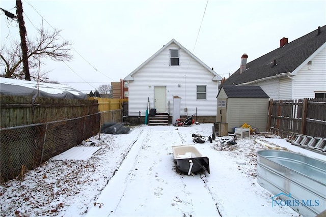 snow covered house with a storage unit