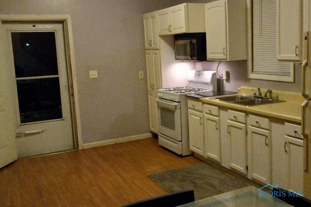 kitchen with wood-type flooring, sink, and white gas range oven