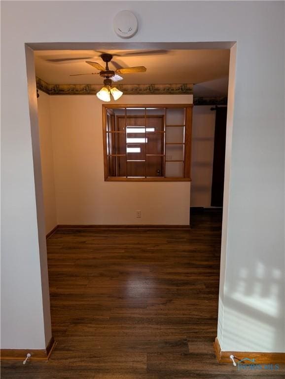 empty room featuring dark hardwood / wood-style flooring and ceiling fan