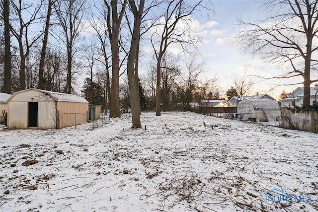 yard layered in snow with a storage unit