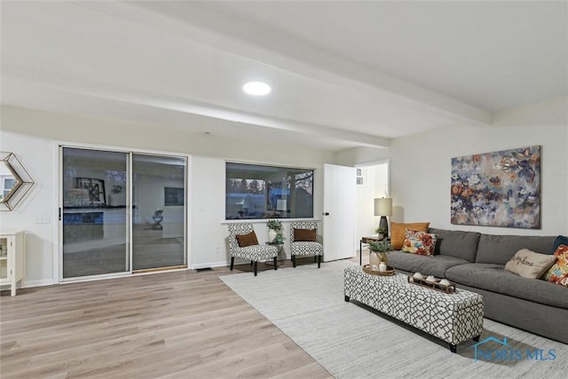 living room with beam ceiling and light hardwood / wood-style floors