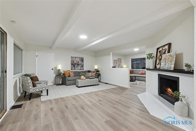 living room with beam ceiling and light wood-type flooring