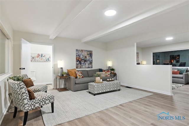 living room with beam ceiling and light hardwood / wood-style flooring