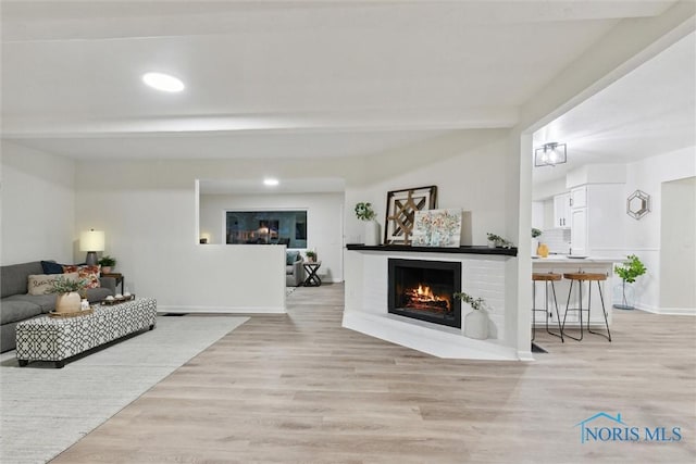 living room with beam ceiling and light hardwood / wood-style floors