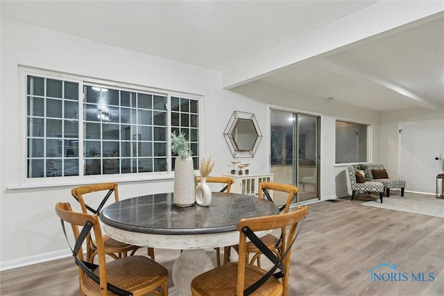 dining room with hardwood / wood-style flooring and beam ceiling