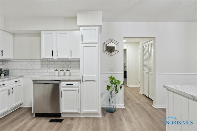 kitchen featuring white cabinetry, stainless steel dishwasher, backsplash, and light wood-type flooring