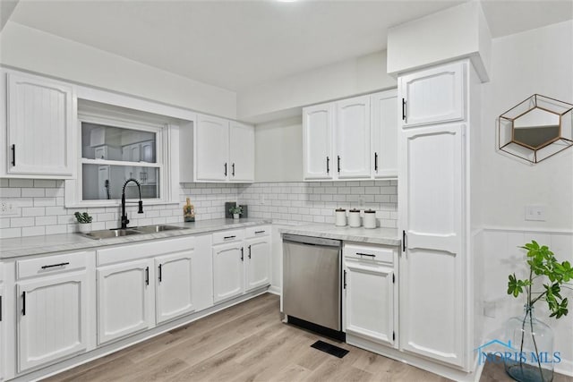 kitchen featuring sink, white cabinetry, tasteful backsplash, stainless steel dishwasher, and light wood-type flooring