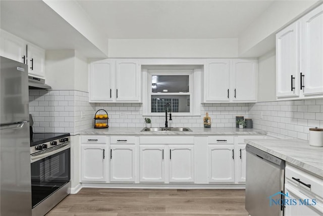 kitchen featuring white cabinetry, stainless steel appliances, sink, and backsplash