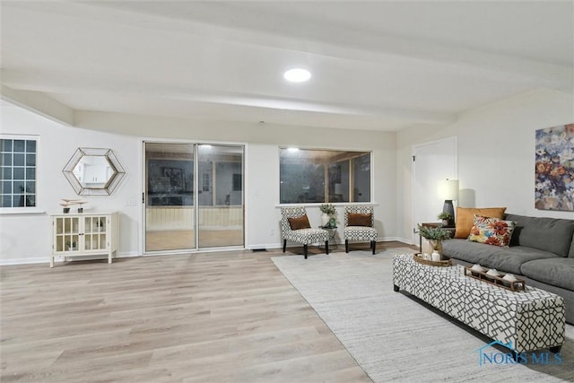 living room with beamed ceiling and light hardwood / wood-style floors