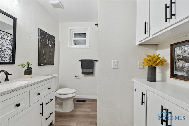 bathroom featuring hardwood / wood-style flooring, vanity, and toilet