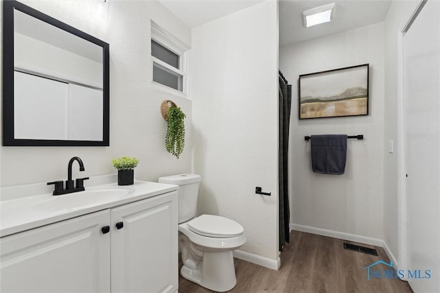 bathroom with vanity, wood-type flooring, and toilet