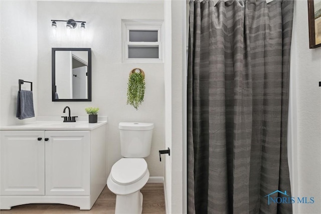 bathroom featuring hardwood / wood-style flooring, vanity, and toilet