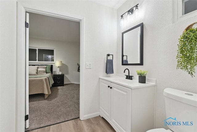 bathroom with hardwood / wood-style flooring, vanity, and toilet