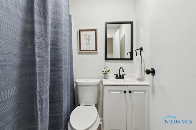 bathroom with a shower with curtain, vanity, and toilet