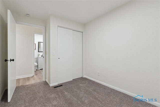 unfurnished bedroom featuring carpet flooring and a closet