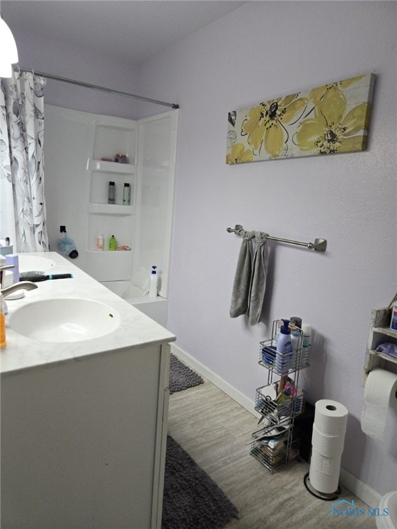 bathroom featuring hardwood / wood-style flooring, vanity, and shower / bathtub combination with curtain