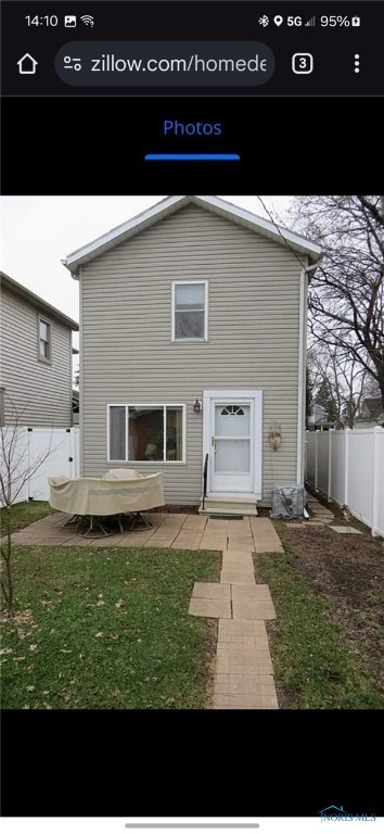 rear view of house featuring a patio and a lawn