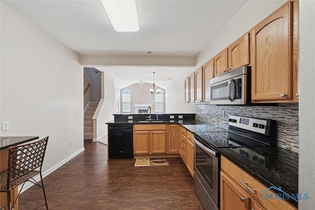 kitchen featuring sink, lofted ceiling with beams, hanging light fixtures, appliances with stainless steel finishes, and decorative backsplash