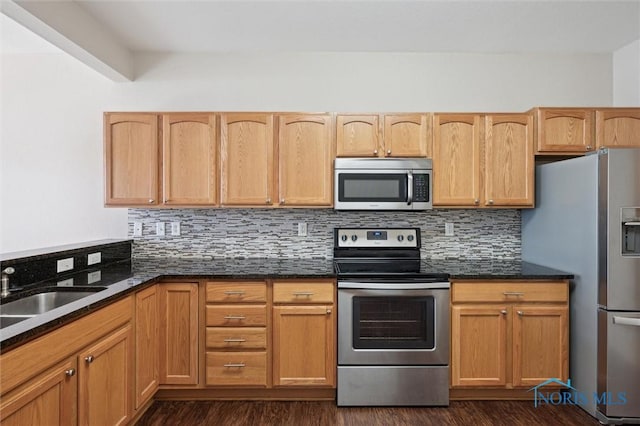 kitchen featuring dark stone countertops, backsplash, and appliances with stainless steel finishes